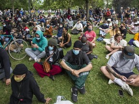 Supporters sit outside a fenced-off homeless encampment in the southern part of Trinity Bellwoods Park in Toronto on Tuesday June 22, 2021.