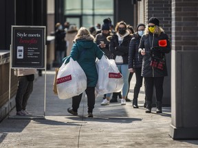 A shopper walks with shopping bags as non-essential in-store shopping returned to Toronto back in March 2021.