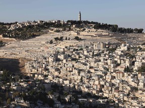 A picture taken on June 3, 2021, shows the predominantly Arab neighbourhood of Silwan, just outside the Old City in Israeli-annexed east Jerusalem, and the Jewish cemetary of Mount of Olives.