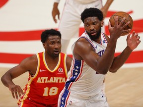Joel Embiid of the Philadelphia 76ers catches a pass against Solomon Hill of the Atlanta Hawks during the first half of Game 3 of the Eastern Conference Semifinals at State Farm Arena on June 11, 2021 in Atlanta, Ga.