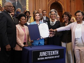 Speaker of the House Nancy Pelosi (D-CA) holds a bill enrollment signing ceremony for the Juneteenth National Independence Day Act as members of the Congressional Black Caucus hold the bill on June 17, 2021 on Capitol Hill in Washington.