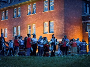Kamloops residents and First Nations people gather to listen to drummers and singers at a memorial in front of the former Kamloops Indian Residential School after the remains of 215 children, some as young as three years old, were found at the site last week, in Kamloops, B.C., May 31, 2021.