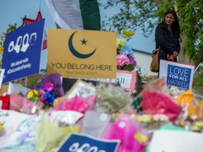 A person stands near a makeshift memorial at the scene where a Muslim family was killed in what police describe as a hate-motivated attack, at the London Muslim Mosque in London, Ont., June 12, 2021.