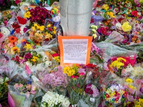 Flowers are left at a makeshift memorial at the fatal crime scene where a man driving a pickup truck jumped the curb and ran over a Muslim family in what police say was a deliberately targeted anti-Islamic hate crime, in London, Ont., June 8, 2021.