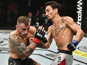 In this handout image provided by UFC, Max Holloway punches Alexander Volkanovski in their UFC featherweight championship fight during UFC 251 at Flash Forum on UFC Fight Island on July 12, 2020 on Yas Island, Abu Dhabi, United Arab Emirates.