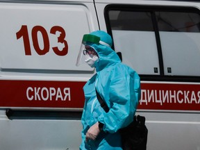A medical specialist walks by an ambulance outside a hospital for patients infected with the coronavirus disease in Moscow, Russia June 16, 2021.