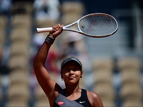 Japan's Naomi Osaka celebrates after winning against Romania's Patricia Maria Tig during their women's singles first round tennis match on Day 1 of The Roland Garros 2021 French Open tennis tournament in Paris on May 30, 2021.