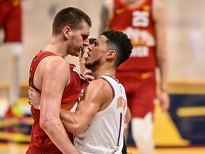 Nikola Jokic of the Denver Nuggets and Devin Booker of the Phoenix Suns exchange words after a play that would result in Jokic being ejected in the third quarter in Game 4 of the Western Conference second-round playoff series at Ball Arena on June 13, 2021 in Denver, Col.