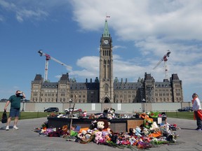 Children's shoes and toys are placed at the foot of the Centennial Flame in honour of the 215 indigenous children remains found at a boarding school in British Columbia, on Parliament Hill June 1, 2021 in Ottawa.