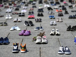 Dried flowers rest inside a pair of child's running shoes at a memorial for the 215 children whose remains were found at the grounds of the former Kamloops Indian Residential School at Tk’emlups te Secwépemc First Nation in Kamloops, B.C., on Parliament Hill in Ottawa on Friday, June 4, 2021.