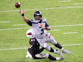 Seattle Seahawks quarterback Russell Wilson (3) throws while being tackled by Arizona Cardinals outside linebacker Haason Reddick (43) at State Farm Stadium.