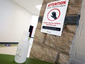COVID-19 prevention signs and hand sanitizer are seen inside St. Marguerite School in Calgary, Aug. 25, 2020.