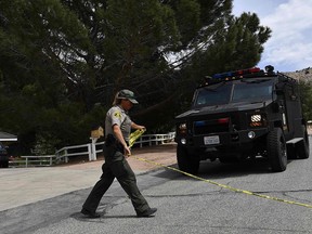 Law enforcement activity is seen near a burning house of a suspected gunman of a shooting at a fire station in Agua Dulce, on June 1, 2021 in Acton, California.