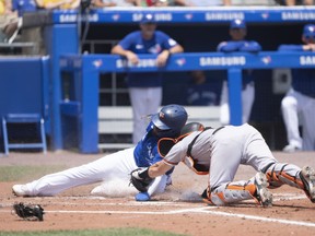 Baltimore Orioles catcher Austin Wynn tags out Blue Jays' Vladmir Guerrero Jr. sliding into home plate during the third inning at Sahlen Field on Sunday, June 27, 2021.