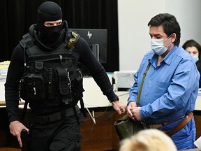 Slovak businessman Marian Kocner is escorted by a security officer for a public hearing at the Slovak Supreme Court as he and Tomas Szabo appear on charges of ordering and carrying out the murders of investigative journalist Jan Kuciak and his fiancee Martina Kusnirova, in Bratislava, Slovakia, June 15, 2021.