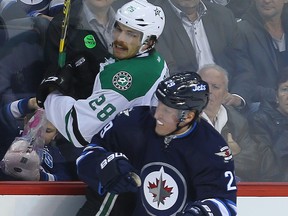 Dallas Stars defenceman Stephen Johns is checked by Winnipeg Jets right winger Patrik Laine during a game in Winnipeg, Nov. 8, 2016.