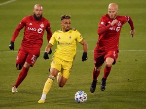 Nashville SC midfielder Hany Mukhtar (10) drives the ball against Toronto FC midfielder Nick DeLeon (18) and midfielder Michael Bradley (4) in the first half of the Eastern Conference Play in Round at Pratt & Whitney Stadium at Rentschler Field in East Hartford, Conn., on Nov. 24, 2020.