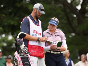 Brooke Henderson of Canada consults with  caddie Everette Nini during the second round of the Meijer LPGA Classic for Simply Give at Blythefield Country Club on June 18, 2021 in Grand Rapids, Mich.