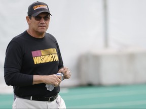 Washington Football Team head coach Ron Rivera stands on the field prior to drills as part of an OTA at Inova Sports Performance Center in Ashburn, Va., June 2, 2021.