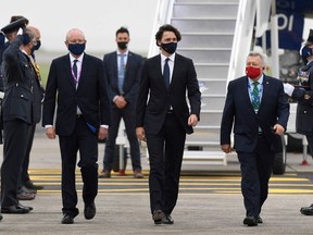 Canada's Prime Minister Justin Trudeau (C), wearing a face covering due to Covid-19, waves after landing at Cornwall Airport Newquay, near Newquay, Cornwall, on June 10, 2021, ahead of the three-day G7 summit being held from 11-13 June.