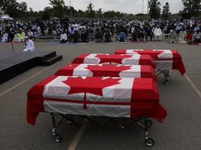 Flag-draped coffins are seen outside the Islamic Centre of Southwest Ontario on June 12, 2021, during a funeral for four members of the Afzaal family who were killed in what police describe as a hate-motivated attack in London, Ontario, Canada.
