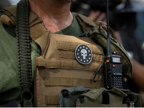 A militia member with body armor and a Three Percent militia patch stands in Stone Mountain as various militia groups stage rallies at Stone Mountain, Georgia, U.S. August 15, 2020.