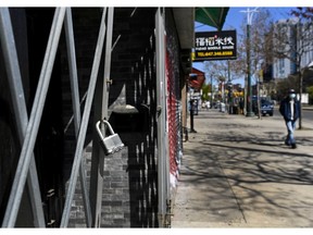 People walk past businesses on Spadina Avenue in Chinatown in Toronto on Thursday, May 13, 2021.