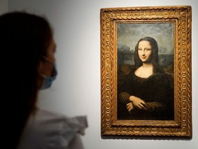 A woman looks at the Hekking “Mona Lisa,” a reproduction of Leonardo Da Vinci’s Mona Lisa, painted on canvas by an unknown artist from the 17th century and up for an online sale at Christie’s auction house in Paris, France, June 11, 2021.