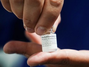 A healthcare worker shows a vial of the Pfizer/BioNTech vaccine against the coronavirus disease (COVID-19) at a parking lot of an exhibition centre turned into a vaccination centre, in Bogota, Colombia June 8, 2021.