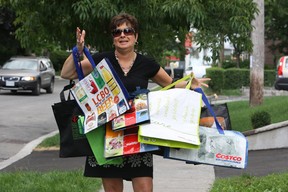 Sue-Ann Levy holds a variety of cloth bags after the 5-cent plastic bag tax was introduced in Toronto in 2010.