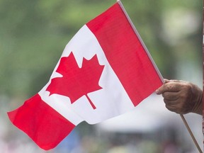 A man waves a flag during a Canada Day parade in Montreal, on July 1, 2018.