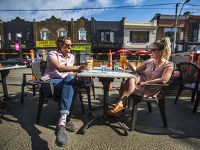 Victor Pokinko and Lauren Vandervoort on Utopia's patio along College St. in the Little Italy neighbourhood  as Ontario moves to Step 1 reopening in Toronto, Ont. on Friday June 11, 2021. Ernest Doroszuk/Toronto Sun/Postmedia