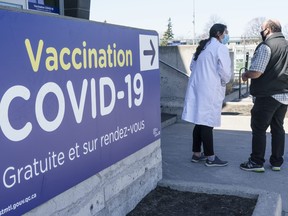 A man is greeted at a COVID-19 vaccination clinic at the Martin Brodeur Arena in Montreal, on Tuesday, April 13, 2021.