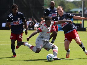 Toronto FC forward Ayo Akinola (20) shoots as New England Revolution's Henry Kessler (4) defends during a game last year.