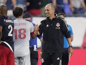 Toronto FC interim coach Javier Perez (right) is congratulated by midfielder Nick DeLeon after defeating the New England Revolution.