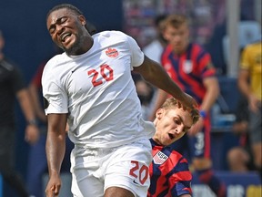 James Sands of the United States tackles Ayo Akinola of Canada from behind, during the first half of the 2021 CONCACAF Gold Cup match at Children's Mercy Park on July 18, 2021 in Kansas City, Kansas.