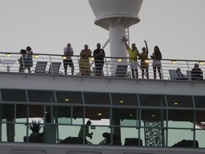 Passengers wave as the Royal Caribbean Freedom of the Seas gets underway through the Government Cut shipping channel at PortMiami on June 20, 2021.