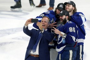 Head coach Jon Cooper of the Tampa Bay Lightning takes a selfie with Andrei Vasilevskiy #88, Mikhail Sergachev #98 and Nikita Kucherov #86 after defeating the Montreal Canadiens 1-0 in Game Five to win the 2021 NHL Stanley Cup Final at Amalie Arena on July 07, 2021 in Tampa, Florida. (Photo by Mike Carlson/Getty Images)