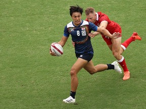 Chihito Matsui of Team Japan runs with the ball under pressure from Conor Trainor of Team Canada during the Men's Pool B Rugby Sevens match between Canada and Japan on day four of the Tokyo 2020 Olympic Games at Tokyo Stadium on July 27, 2021 in Chofu, Tokyo, Japan.