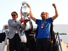 Italy's coach Roberto Mancini (left) and captain  Giorgio Chiellini lift The Henri Delaunay Trophy after travelling back to Rome following their Euro 2020 victory.