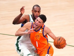 Phoenix Suns guard Devin Booker drives to the basket as Milwaukee Bucks forward Khris Middleton defends during Wednesday's game.