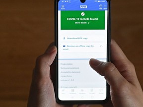This illustration  shows a smartphone screen displaying a Covid-19 vaccine record on the National Health Service (NHS) app in London, England, on May 18, 2021.