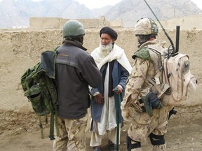 Warrant Officer Chuck Graham questions an Afghan elder about Taliban activity in the Panjwaii district, Afghanistan, through an Afghan interpreter on March 20, 2007.