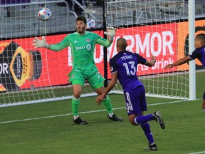 Orlando City forward Tesho Akindele (13) scores a goal past Toronto FC goalkeeper Alex Bono  next to midfielder Junior Urso (11) at Orlando City Stadium.