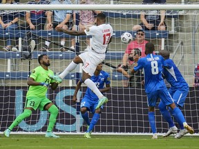 Canada forward Cyle Larin (17) scores a goal against Martinique goalkeeper Meslien Gilles during a CONCACAF Gold Cup group stage match in Kansas City last night.