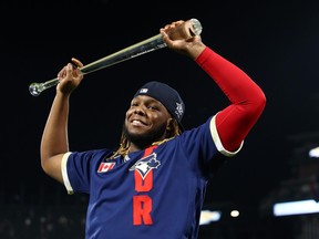 American League first baseman Vladimir Guerrero Jr. of the Blue Jays hold up his trophy after being named MVP of the 2021 MLB all star game at Coors Field on July 14 in Denver.