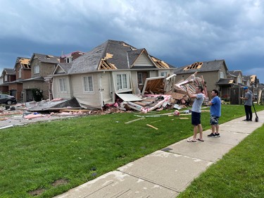 People survey damaged houses in the aftermath of a possible tornado in Barrie on July 15, 2021.  BRANDON VIEIRA/REUTERS