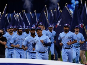 Manager Charlie Montoyo leads the Toronto Blue Jays on to the field at the 
Rogers Centre last night for the pre-game ceremony and you can tell by the excited looks on their faces that this was more than just your traditional home opener.