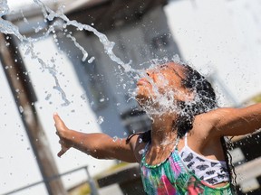 In this file photo kids cool off at a community water park on a scorching hot day in Richmond, B.C., June 29, 2021.