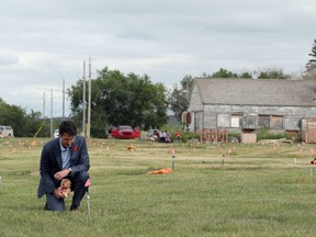 Canada's Prime Minister Justin Trudeau kneels to place a teddy bear at an unmarked grave on Cowessess First Nation, where a search had found 751 unmarked graves from the former Marieval Indian Residential School near Grayson, Sask., July 6, 2021.